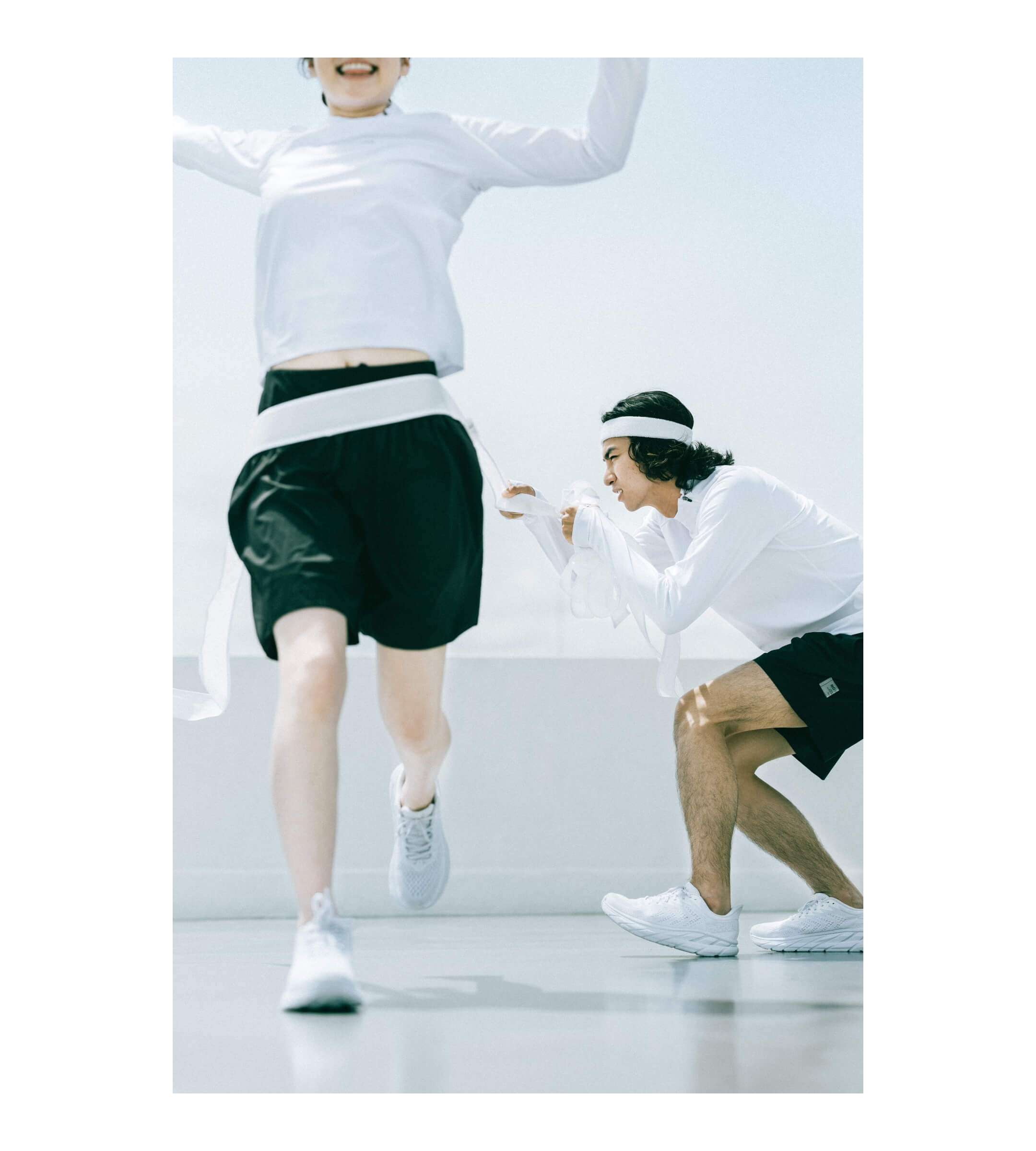 ゴールテープを切る女性とゴールテープを持つ男性