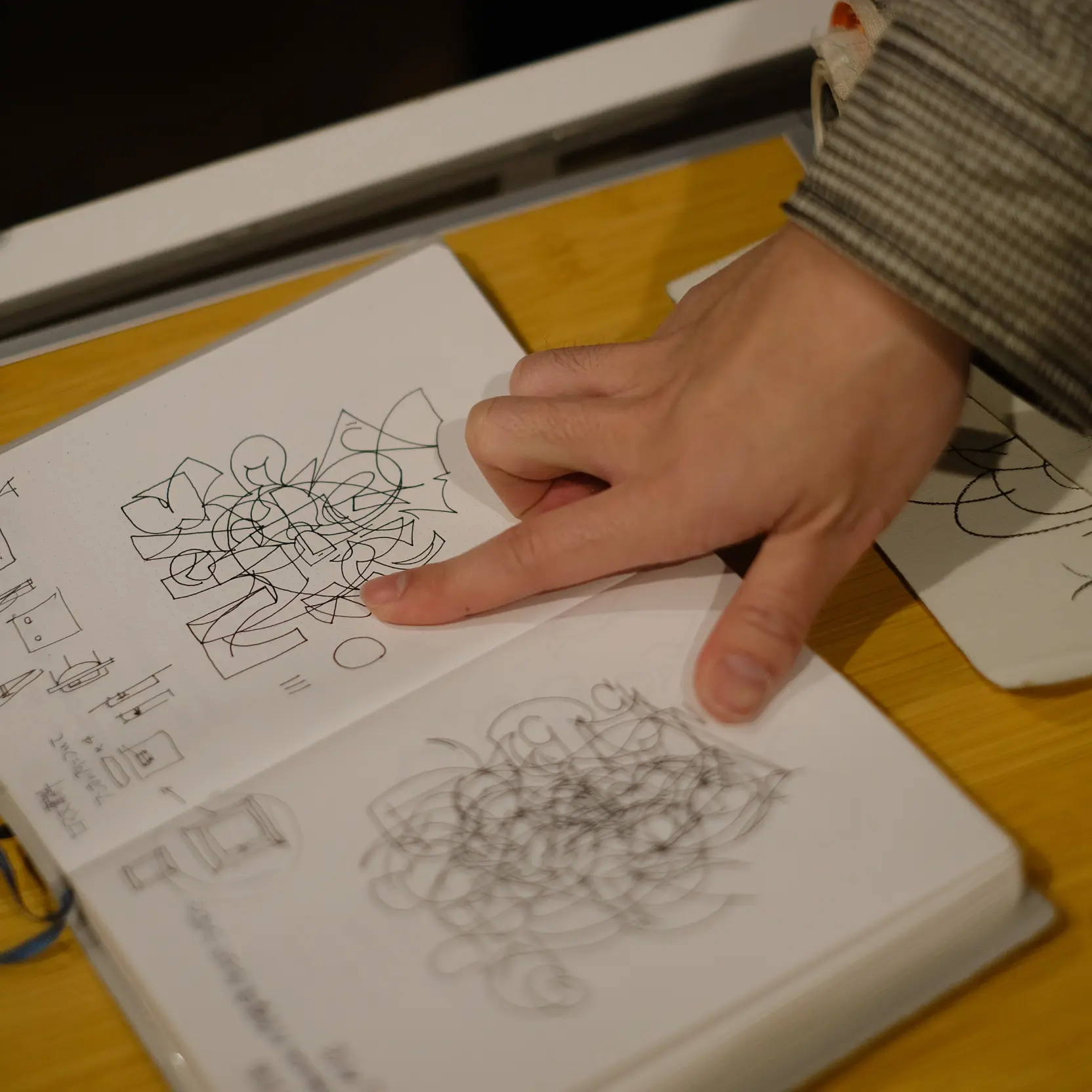 手帳に描いた絵を指さす