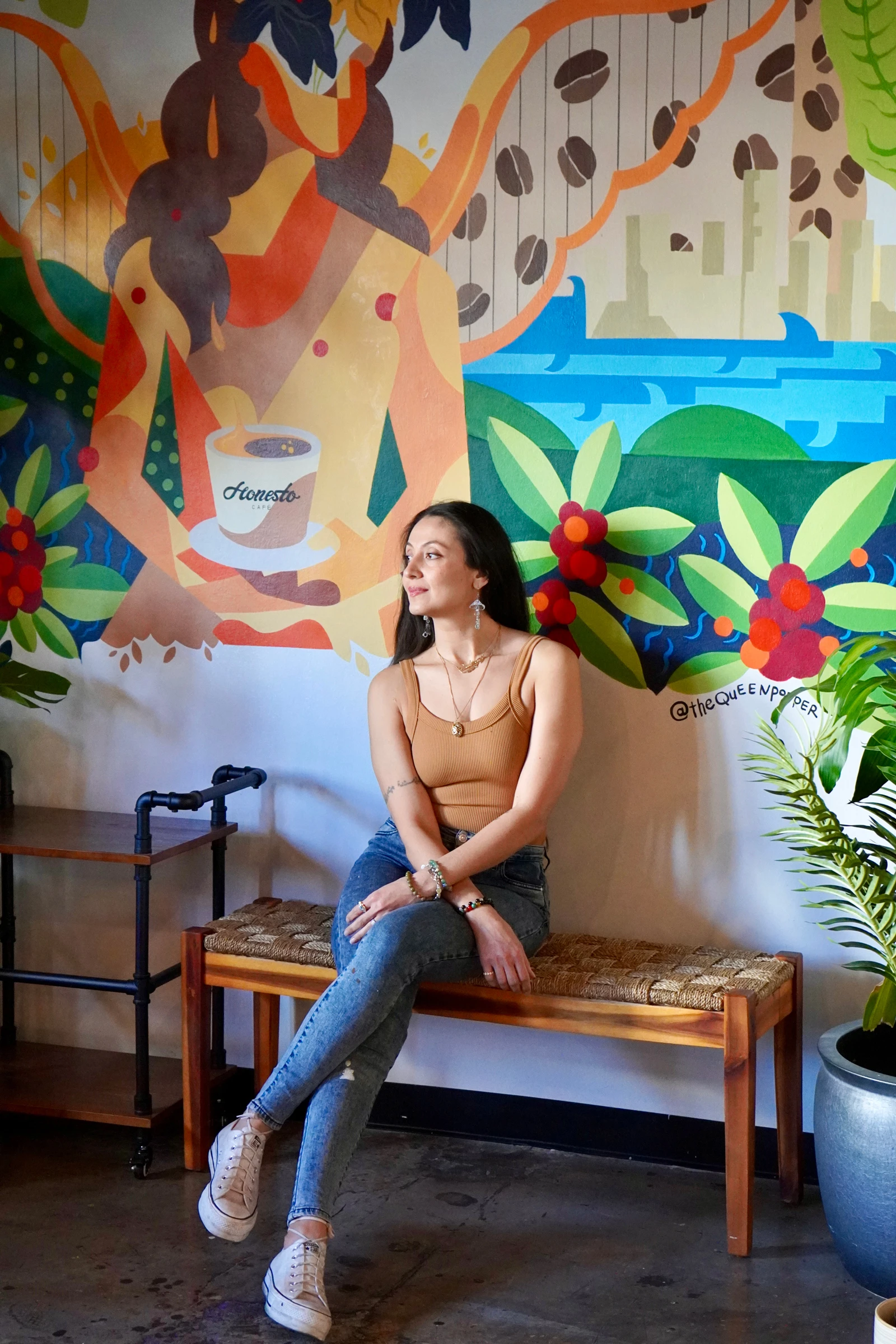 カラフルで大きな絵の前に座るSulmazさん