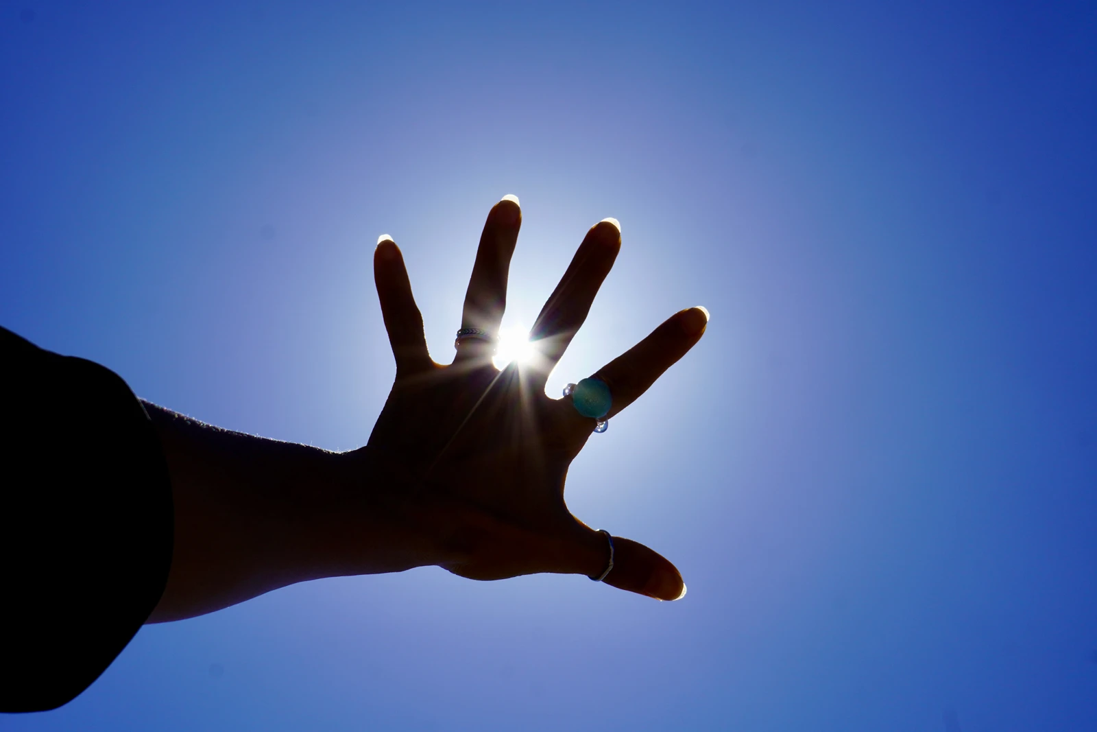 太陽に手をかざす