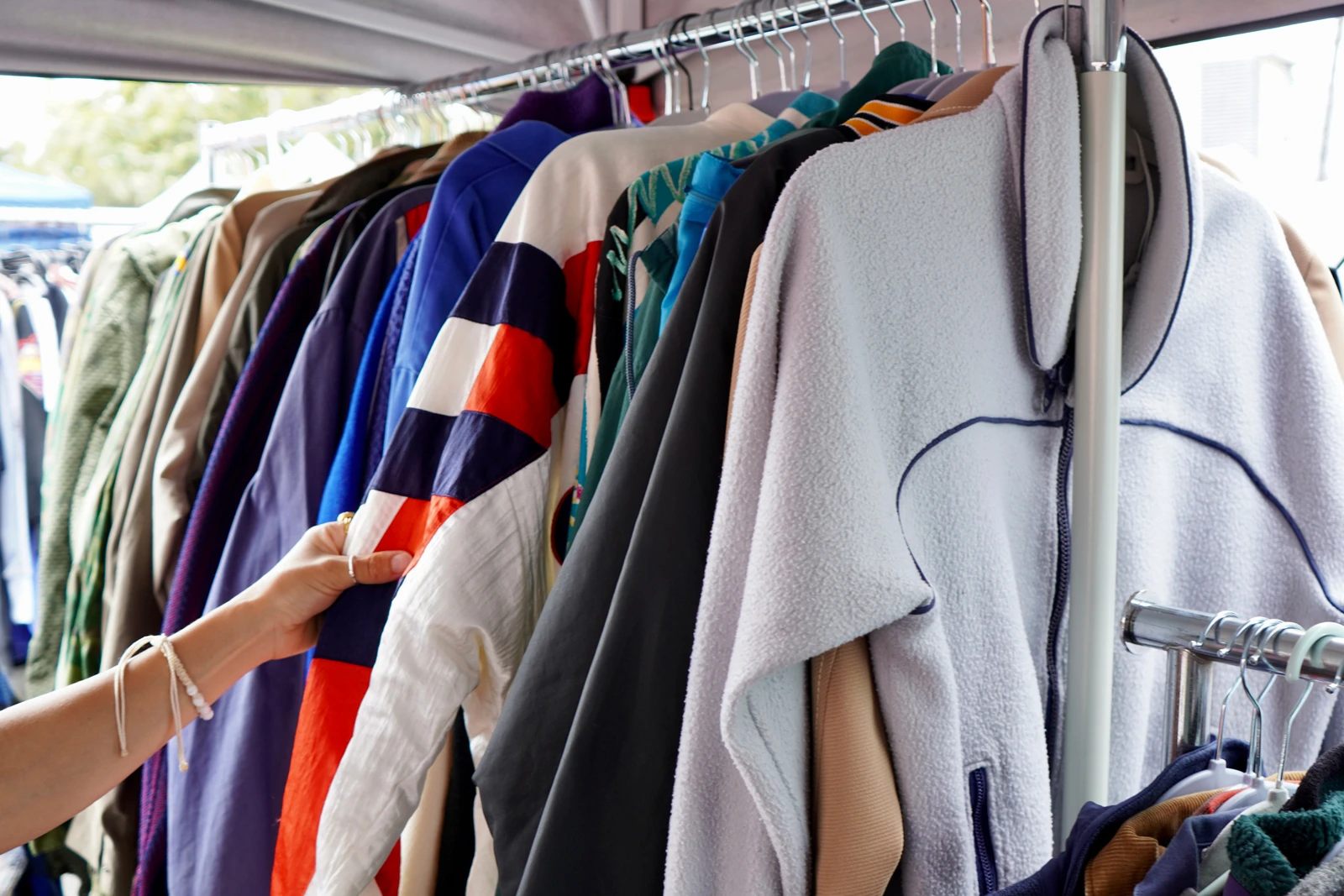 様々な服がハンガーラックにかけられている